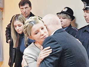 Последние объятия перед 7-летним расставанием. Юлию Тимошенко успокаивает ее муж Александр, за спиной у нее - дочь Евгения