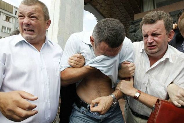 В лицо Кличко (в центре) брызнули аэрозолем - видимо, решив: когда боксер протрет глаза, он наконец разглядит значение русского языка для украинцев.